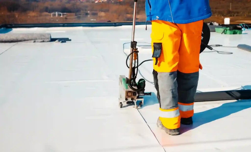 Roofing contractor using machinery on a flat roof